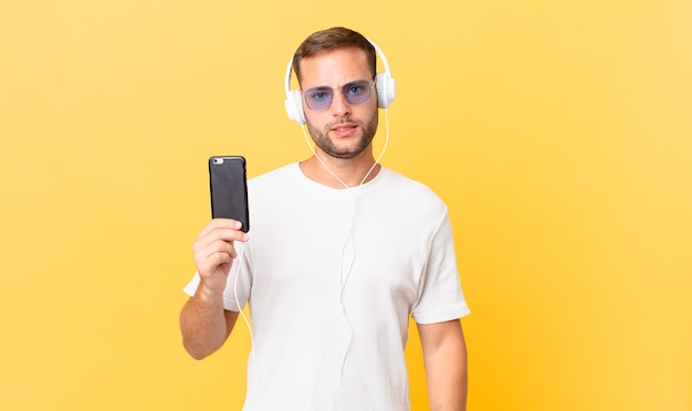 Sentindo-se intrigado e confuso, ouvindo música com fones de ouvido e um smartphone