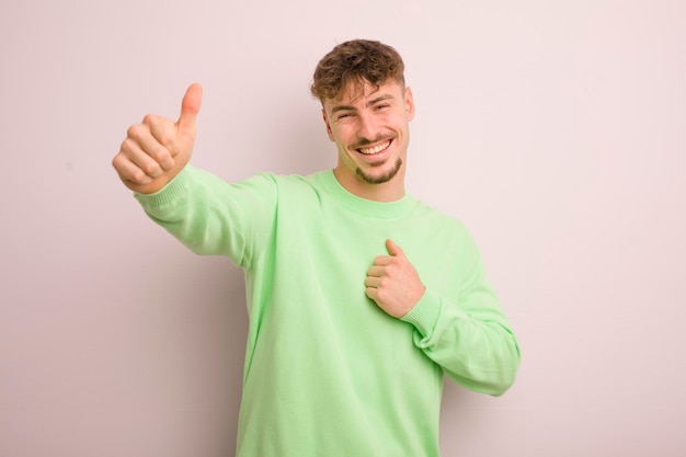 Sentindo-se orgulhoso despreocupado confiante e feliz sorrindo positivamente com polegares para cima