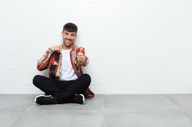 sentindo-se orgulhoso, despreocupado, confiante e feliz, sorrindo positivamente com polegares para cima