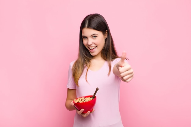 sentindo-se orgulhoso, despreocupado, confiante e feliz, sorrindo positivamente com polegares para cima