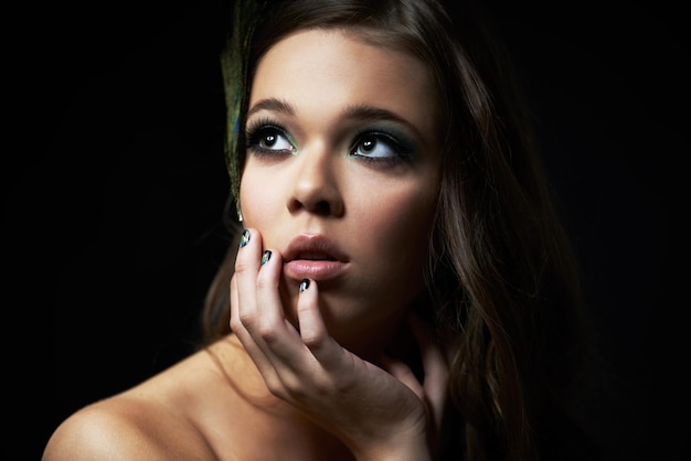 Sentindo-se pensativo Foto de uma jovem com maquiagem dramática olhando para longe pensativamente