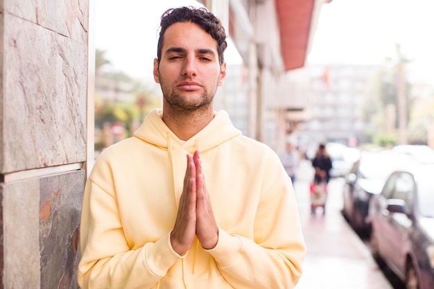 Sentindo-se preocupado, esperançoso e religioso orando fielmente com as palmas das mãos pressionadas implorando perdão