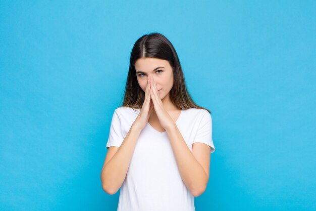 sentindo-se preocupado, esperançoso e religioso, orando fielmente com as palmas das mãos pressionadas, pedindo perdão