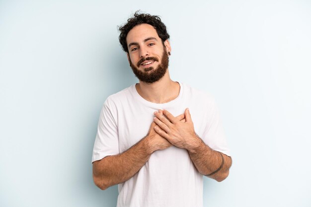 Sentindo-se romântico feliz e apaixonado sorrindo alegremente e segurando as mãos perto do coração