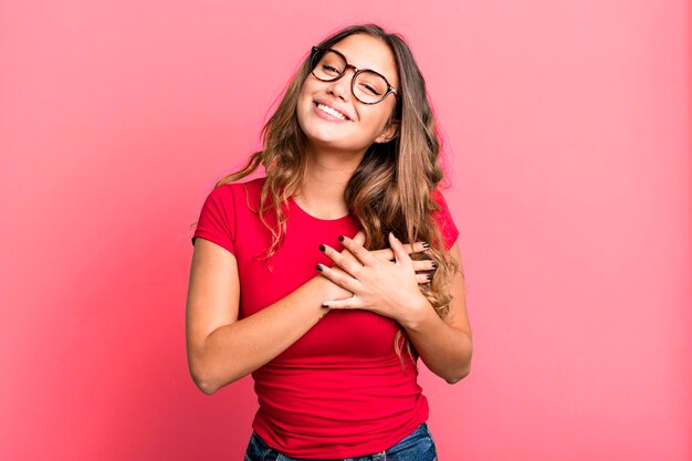 Sentindo-se romântico feliz e apaixonado sorrindo alegremente e segurando as mãos perto do coração