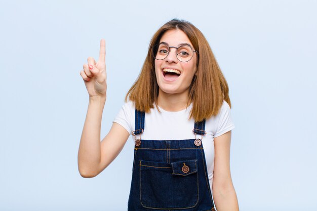 sentindo-se um gênio feliz e animado depois de realizar uma ideia, levantando alegremente o dedo, eureka!