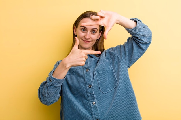 Sentir-se feliz, amigável e positivo, sorrindo e fazendo um retrato ou moldura com as mãos