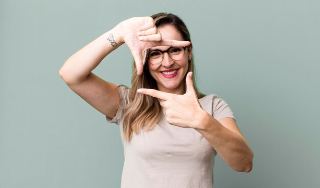 Sentir-se feliz, amigável e positivo, sorrindo e fazendo um retrato ou moldura com as mãos