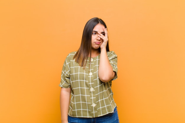 sentirse aburrido, frustrado y con sueño después de una tarea aburrida, aburrida y tediosa, sosteniendo la cara con la mano