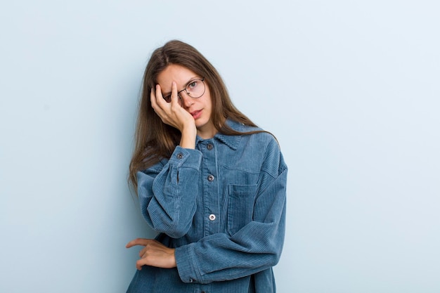 sentirse aburrido, frustrado y con sueño después de una tarea aburrida y tediosa, sosteniendo la cara con la mano