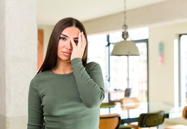 sentirse aburrido, frustrado y con sueño después de una tarea aburrida y tediosa, sosteniendo la cara con la mano