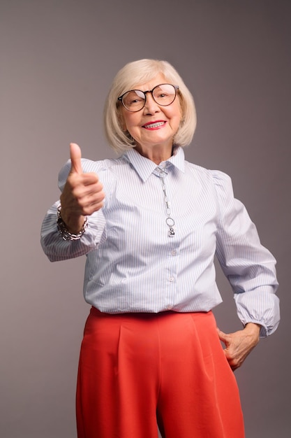 Sentirse bien. Una anciana guapa con anteojos que se siente bien y confiada