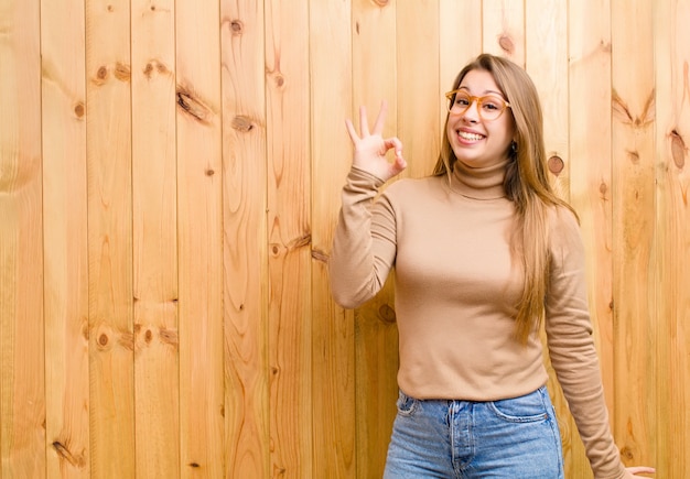 sentirse exitoso y satisfecho, sonreír con la boca abierta, hacer una señal con la mano