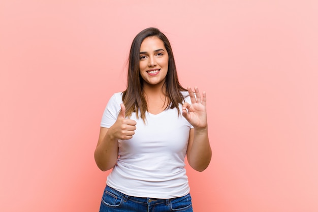 Foto sentirse feliz, asombrado, satisfecho y sorprendido, mostrando gestos de aprobación y pulgares arriba, sonriendo