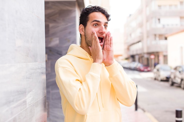 Sentirse feliz emocionado y sorprendido mirando hacia un lado con ambas manos en la cara