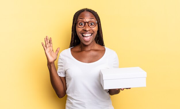 Sentirse feliz, emocionado, sorprendido o conmocionado, sonriendo y asombrado por algo increíble y sosteniendo una caja vacía.