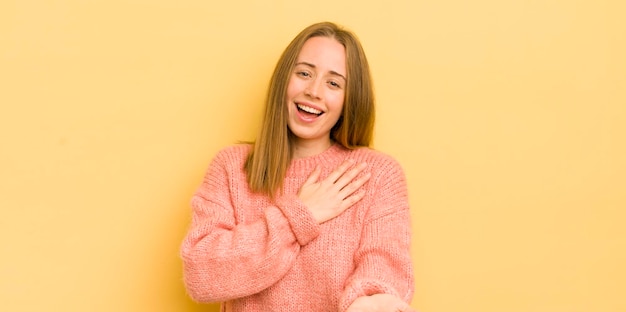 Sentirse feliz y enamorado sonriendo con una mano al lado del corazón y la otra estirada al frente