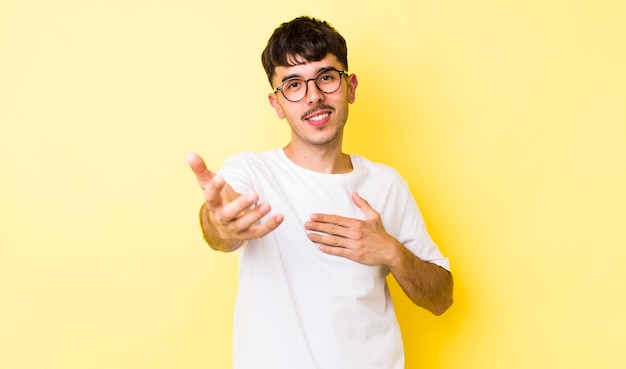 Sentirse feliz y enamorado sonriendo con una mano al lado del corazón y la otra estirada al frente