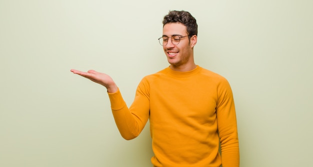 sentirse feliz y sonriendo casualmente, mirando a un objeto o concepto sostenido en la mano en el costado