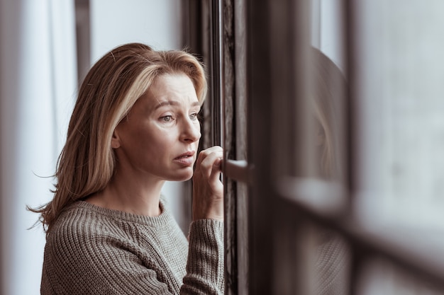 Sentirse preocupado. Hermosa mujer madura se siente preocupada al ver al marido con otra mujer