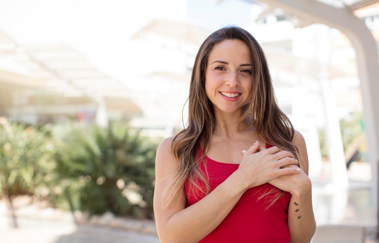 Foto sentirse romántico feliz y enamorado sonriendo alegremente y sosteniendo las manos cerca del corazón