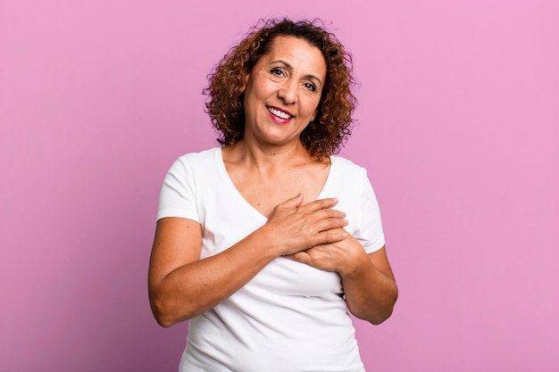 Sentirse romántico feliz y enamorado sonriendo alegremente y tomados de la mano cerca del corazón