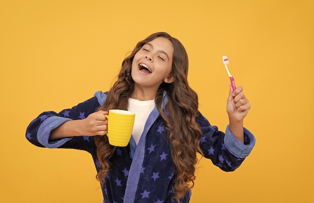 Sentirse tan feliz odontología para niños niña adolescente con cepillo de dientes y taza niño feliz cepillarse los dientes