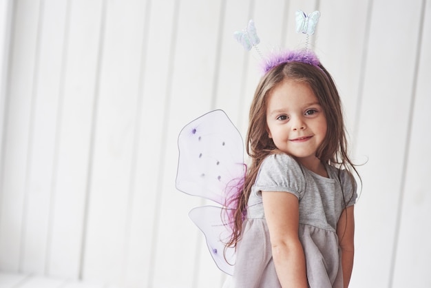 Sentirse tranquilo y feliz. Hermosa niña con traje de hadas divirtiéndose posando para las fotos.