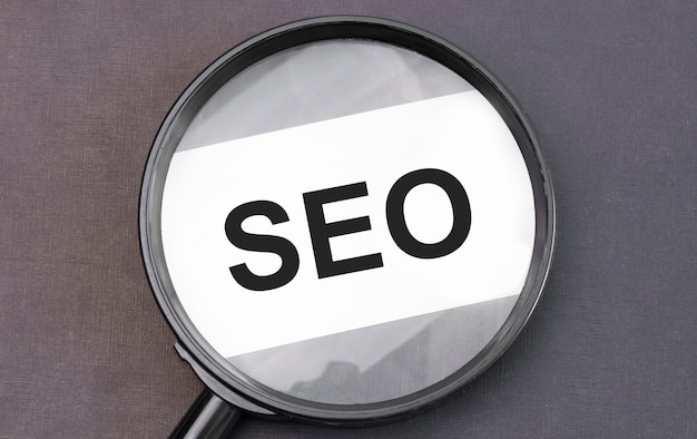 SEO-Wort auf Papier durch Lupe.