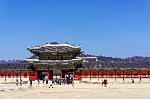 Foto seoul, südkorea - 11. märz 2016: eingang zum königspalast gyeongbokgung in seoul, südkorea, im frühjahr. es war ein königlicher palast und ist einer der fünf großen paläste der joseon-dynastie. touristen