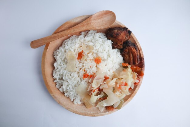 Sepiring nasi dengan lauk ayam goreng dan sayur asam berupa isian terong dan sayur kol