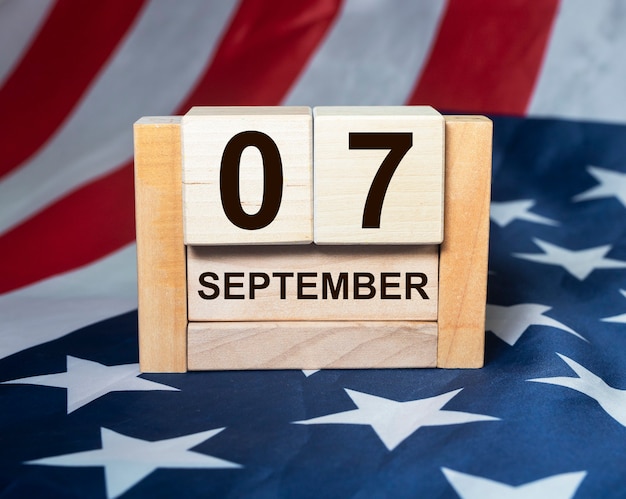 septiembre en el día del trabajo del calendario del cubo de madera sobre la bandera americana