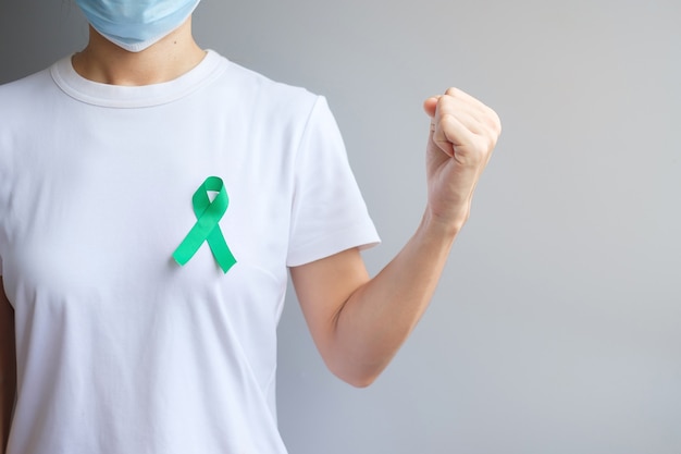 Septiembre Mes de concientización sobre el cáncer de ovario, mujer con cinta de color verde azulado para apoyar a las personas que viven y padecen enfermedades. Conceptos de salud y día mundial contra el cáncer