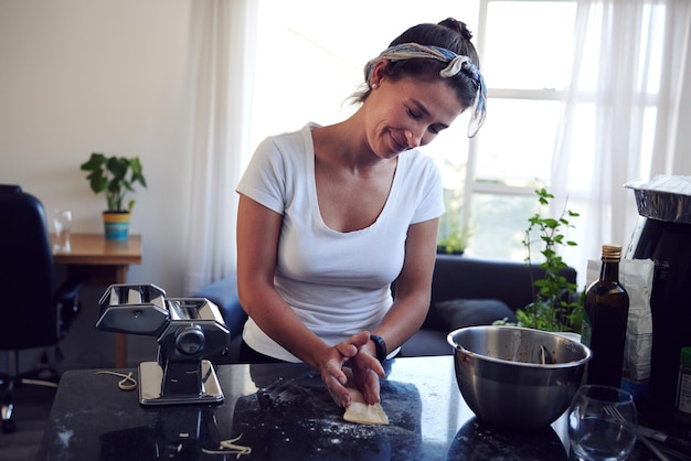 Va a ser delicioso Captura recortada de una joven atractiva cocinando pasta casera en casa