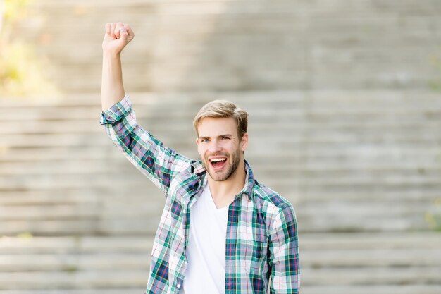 Ser vencedor é uma coisa maravilhosa. Feliz vencedor comemorar ao ar livre. Homem feliz faz gesto de vencedor. Comemorando o sucesso e a conquista. Celebração do triunfo. A vitória é para o vencedor. Ganhe hoje.