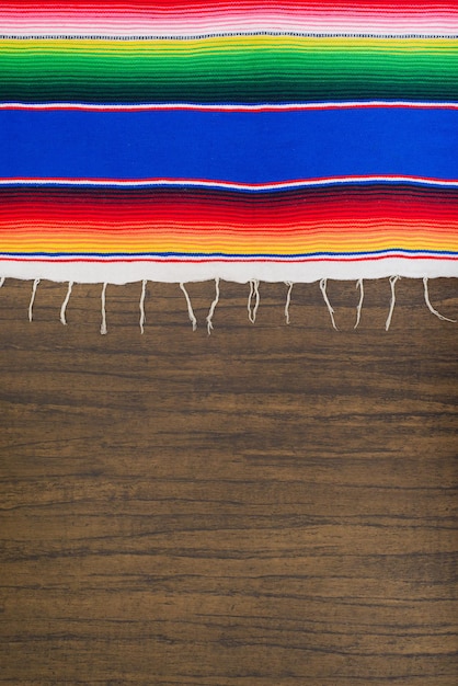Serape de colores en una mesa de madera Tipo de tela de colores de México Textura de fondo
