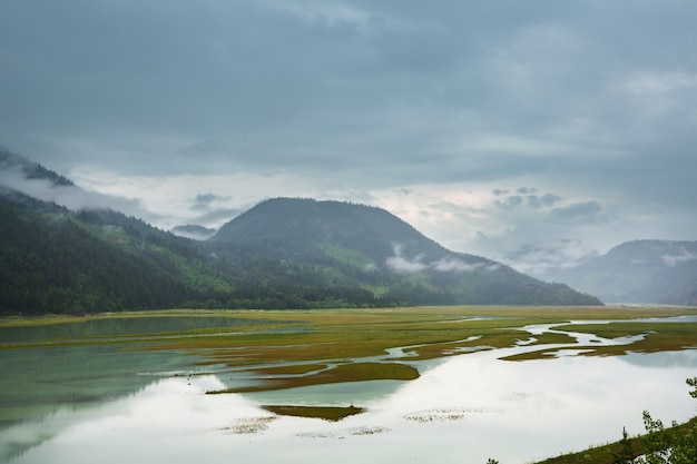 Serena escena junto al lago de montaña en Canadá con el reflejo de las rocas en las tranquilas aguas.