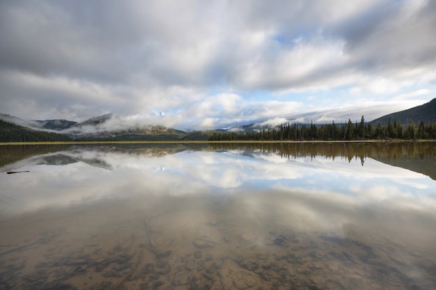 Serena escena junto al lago de montaña en Canadá con el reflejo de las rocas en las tranquilas aguas.