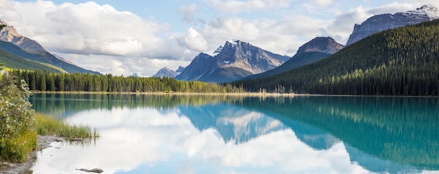 Serena escena junto al lago de montaña en Canadá con el reflejo de las rocas en las tranquilas aguas.