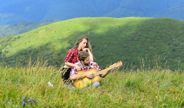 Serenata. aventura de caminhada. amigos felizes com guitarra. amizade. canções de fogueira. música country. data romantica. homens tocam guitarra para menina. casal apaixonado passa tempo livre juntos. acampamento ocidental.