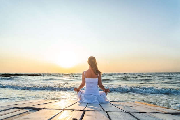 Foto serenidad y practica de yoga en el mar. amanecer