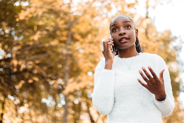 Seria hermosa mujer afroamericana sostener mano teléfono hablando chat amigos colega