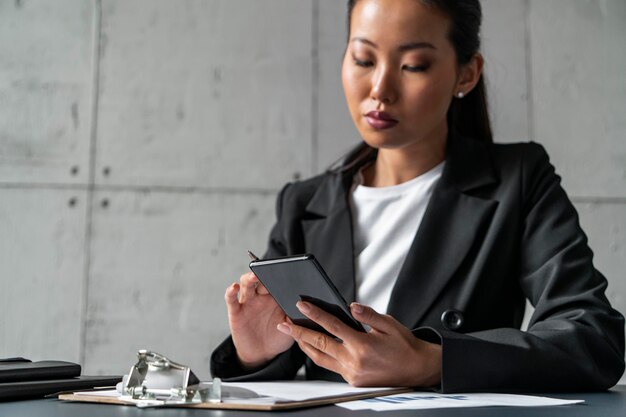 Seria mujer asiática navegando por la web en el teléfono inteligente