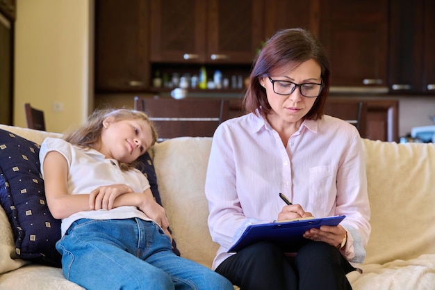 Seria niña triste y maestra psicóloga en la sesión