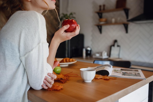 Serie de otoño en la cocina melancolía y calidez Relajarse en climas fríos chica pelirroja disfrutando de manzanas en la cocina