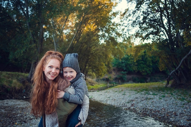 Una serie sobre pelirroja feliz. La hermana mayor y el hermano y la hermana menores. Parque, otoño, río. Momento feliz