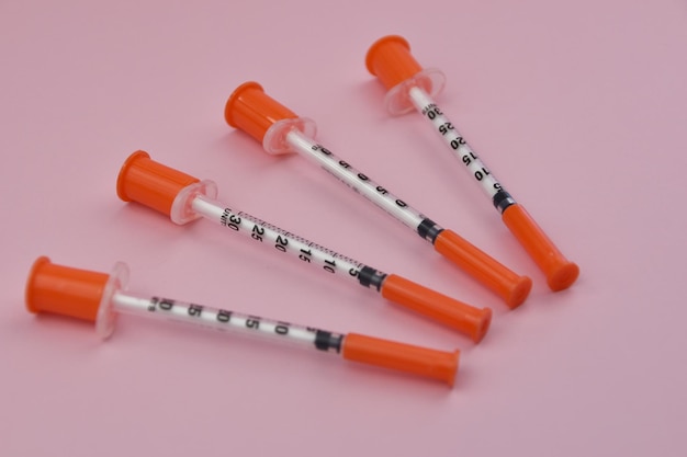 Seringa de insulina para diabetes em fundo rosa conceito de cuidados de saúde