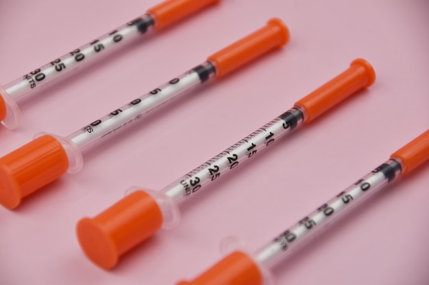 Seringa de insulina para diabetes em fundo rosa conceito de cuidados de saúde