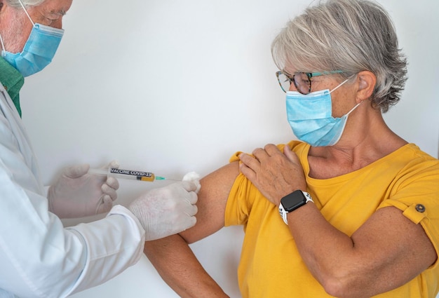 Foto seringa nas mãos de um médico injetando o reforço da vacina de coronavírus covid19 em uma mulher