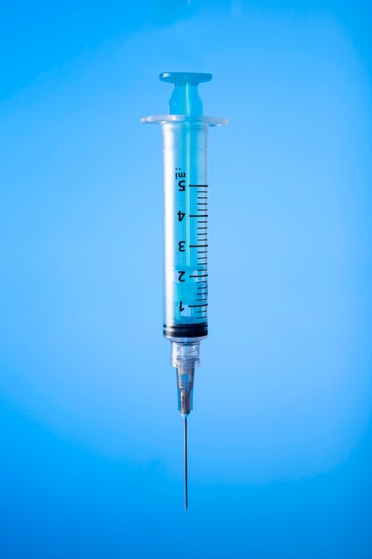 Seringa sobre fundo azul. Prevenção de vacinas. Copie o espaço.